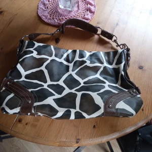Stor mönstrad väska - Fin och tuff väska mönstrad ,ko mönster. Med axelrem. Hämtas i Skene alt skickas o köpare betalar frakten o Swishbetalning tillämpas .frakt inräknat i priset .
