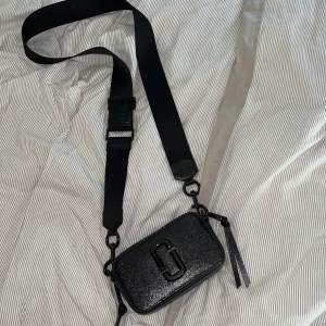 Liten handväska från Marc Jacobs. Saffiano läder, justerbart axelband. Två fack med dragkedja, en ytterficka. Väskan är helt ny aldrig använd, inköpt för 4000kr