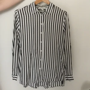 Randig skjorta i 100% Viskos - Vit- och svartrandig oversize skjorta i 100% viskos från Monki. Storlek XS men passar även som M.  Köparen står för fraktkostnaden.