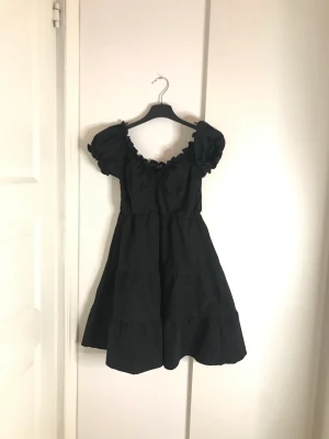 Svart klänning - En svart klänning med puffärmar :). Drar ej med sig smuts 
