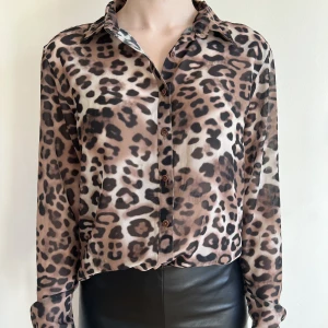 Leopardmönstrad skjorta  - Leopardmönstrad skjorta från NA-KD, storlek 34. Använd 2 ggr, fint skick. Lite trådar vid en söm i ena ärmslutet.