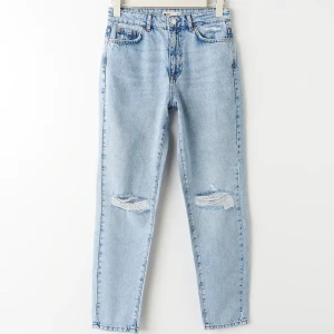 Jeans från Ginatricot - Mom-jeans från Ginatrico, Blåa Mom-jeans från Gina, strl 34, passar även 36. Inte använda på över 1 år och har knappt används. Inga speciella slitningar.