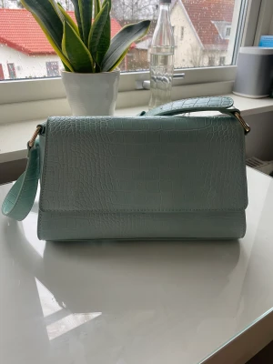 Handväska - Fin, stor och rymlig handväska i bra skick. Fin färg och är jättefin att ha med sig en sommardag. Stort utrymme med ett litet fack på insidan med dragkedja.  fraktkostnad på 39kr tillkommer. 