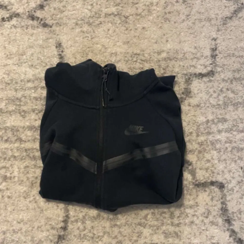 Svart Nike teech hoodie i ett bra skick. Endast en defekt men inte så synlig (se bild 2) Dem är i dam modellen nypris 1 349kr❤️. Hoodies.