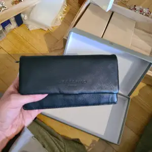 Plånbok i svart skinn från Liebeskind Berlin. Mått ca 18,5 × 11,5 cm. Ny med tygväska och box. 