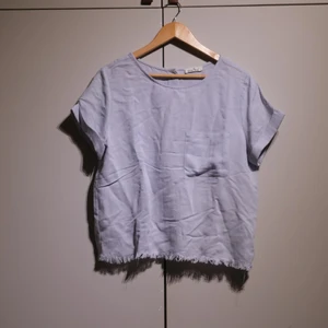 Light blue cotton shirt - Cotton shirt in a light blue, slightly shred at the bottom. Sits wide, in perfect condition. 