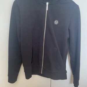 Philip plein hoodie, junior - Säljer på grund av att jag växt ut tröjan. Den är knappt annvänd och har inga täcken på slitage. Köpte den för något år sedan på plein hemsidan för 2600kr. Hoodien är storlek 12/13yrs junior. Man får med box, äkhetsbevis, taggar, extra pärlor mm.