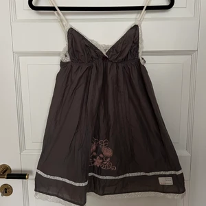 Odd Molly klänning  - Odd Molly klänning i grått med broderier i rosa och vit spets. Jättefint skick förutom liten reva i spetsen (kan enkelt sys ihop om man är händig). Storlek 0 motsvarar xs 