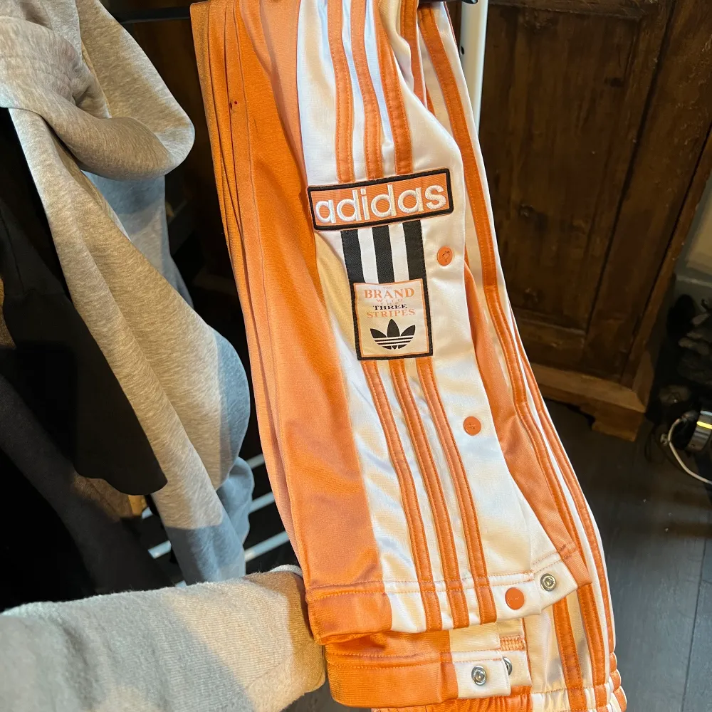 Orangea adidas streetbyxor med knappar på sidorna, strl 38, endast använda 1-2ggr pga fel storlek 😩 billigare vid snabb och smidig affär. Jeans & Byxor.
