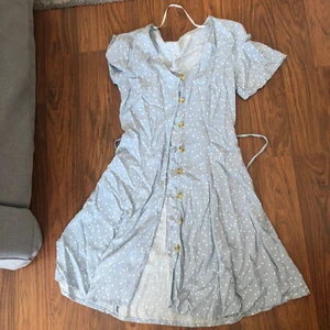 Ljusblå klänning storlek S - En ljusblå klänning med vita prickar i storlek S, litet band som knyts runt midjan