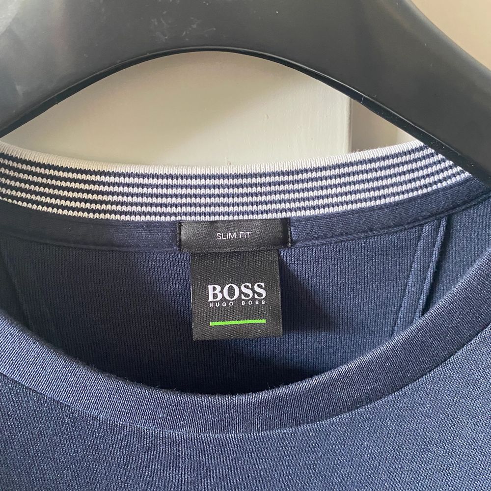 Hugo Boss blå sweatshirt, plagget är i slim fit men sitter som en klassisk sweatshirt. Produkten är använd ett fåtal gånger, men är i väldigt bra skick nästan nyskick. Det finns inga skador eller defekter. . Tröjor & Koftor.