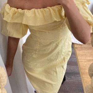 Gud volangklänning - Den perfekta sommarklänningen i linne-tyg. Off shoulder och puffiga armar. Den slutar mitt på låren (jag är 167). Med dragkedja på sidan. Använd en gång. Storlek 36.