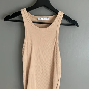 Beighe ribbad topp från NA-KD,storlek xs - Plagget är aldrig använt och är från NA-KD. Säljer pga inte min stil, jättefint nu till sommaren!
