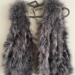 Väst med äkta fjädrar - Ljusgrå väst med äkta fjädrar köpt på Monroe