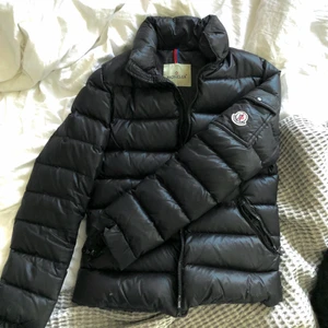 Vintage dunjacka från moncler, svart - Äkta, Halvbra skick, några små hål i tyget, trasig dragkedja men går att laga (saknas en plastbit) skulle säga att storleken är S-M. Vintage och begagnad så tyvärr inget kvitto eller scanner/QR-kod (tillverkad innan de kom)