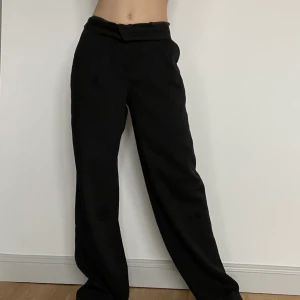 kostymbyxor - Jättefina svarta, tunna, baggy kostymbyxor som tyvärr var lite för långa för mig men passade mig helt perfekt i midjan. Den går att vika ned i midjan. Knappen sitter lite löst men det märker ingen och den går inte av så man behöver inte oroa sig för det!🥰 Knappen är oxå väldigt att sy fast om den råkade gå av. innerbenet- ca 70cm