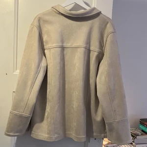 Vårjacka Mockajacka Jacka Beige - En jättefin vårjacka / mockajacka / overshirt från NAKD ca 2019. Den är superlen och härlig. Använd två gånger så superbra skick! Den är oversize (strl 40) en asfin baggy fit på mig som är S/M 💘Kommer tyvärr inte till användning längre.