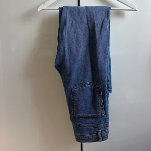 Jeans från Na-kd - Blå jeans från Na-kd! Med knappar som knäppning och i fin kvalite! Jag på bilden är 158cm. 