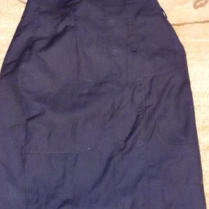 black short skirt with buttons in line at the front of the skirt. - The skirt is been worn 3 times and it's still good looking.