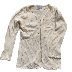 Virkad kofta - En cardigan som är i virkat/stickad material och stängs med knappar. Fint blommigt mönster och har en söt brandy melville vibe 😋💓barn stl 152, passar xs-s. 