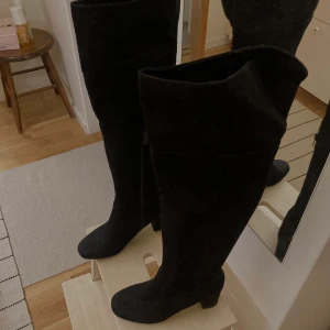 Svarta stövlar med klack storlek 39 - Svarta over-knee stövlar med klack i mocka material. Storlek 39. Finns i Farsta. Skriv för fler bilder  