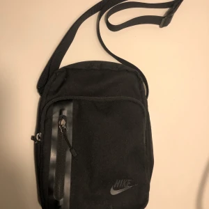 Nike tech axelremsväska - Väska från Nike i mycket bra skick! Köpt för 300 kr och väldigt lite använd!