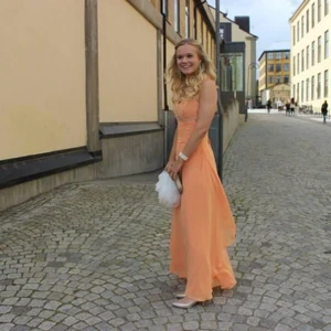 Balklänning  - En balklänning i färg av persika med fina detaljer 