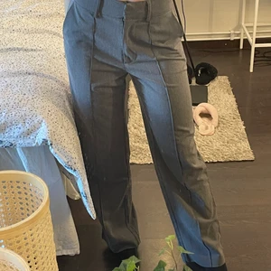 Kostymbyxor - Super snygga gråa kostymbyxor från nakd med pressveck och slits bak i benen. Använda ett fåtal gånger, superfint skick! Jag är 170 som referens. Om flera är intresserade blir det budgivning 💖