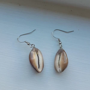 Hemmagjorda snäckörhängen - Hemmagjorda bruna snäckörhängen med vita prickar på. Silverfärgade örhängeskrokar