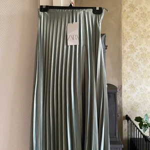 Zara kjol strl S - Fin lång turkos kjol från Zara i glansigt silkesmaterial. Helt oanvänd!
