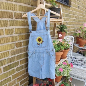 Hängsleshorts - Jättefina hängsleshorts med en broderad solros fram. Har broderat mitten själv. Rekommenderar för någon som är S i storlek. 