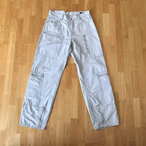 Eytys benz cargobyxor - Cargobyxor från Eytys i beige. Tekniskt tyg i bomull/polyester. Fint skick. Storlek 30. Mått: midja: 42 cm innerbenslängd: 82 cm benöppning: 25 cm 