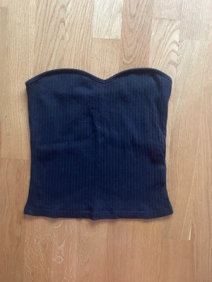 Svart ribbad tubtopp - Svart ribbad tubtopp från SHEIN. As snygg och ha ny till våren och sommaren. Säljer då den inte kommer till användning. För mer bilder/frågor skriv privat 🥰 frakten ingår inte 