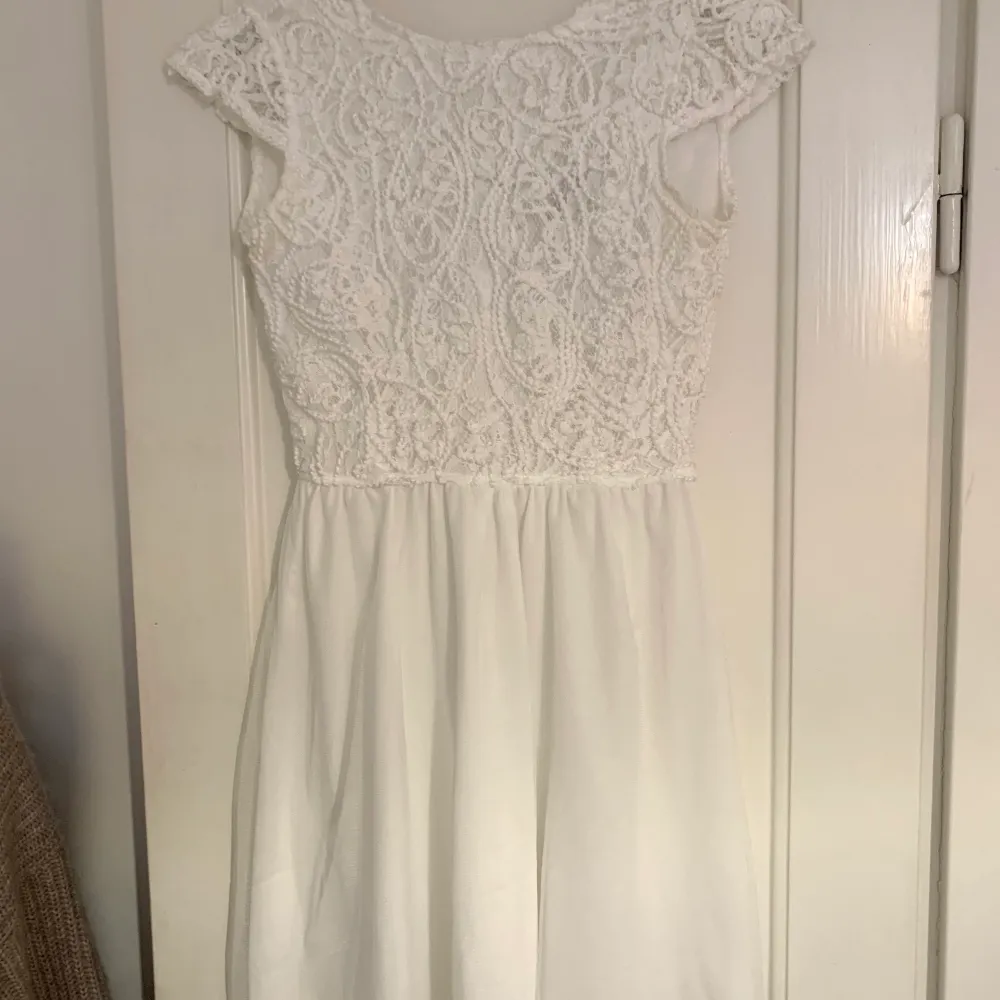 En vit jättefin klänning som passar perfekt till skolavslutningar eller andra fina tillställningar. Den har dragkedja och knappar i ryggen och fint broderi. Den är i storlek 146/157 men sitter som en XS. Klänningar.