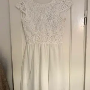 En vit jättefin klänning som passar perfekt till skolavslutningar eller andra fina tillställningar. Den har dragkedja och knappar i ryggen och fint broderi. Den är i storlek 146/157 men sitter som en XS