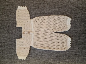 Baby overall - Denna fina baby plagg har jag virkat själv. Garnet är av bomulll. Knapparna är plast. Finns i ett rök och djurfritt hem.  Mått: Mage - 50 cm Axel - 18 cm Hela längden - 34 cm. Löparen står för frakten