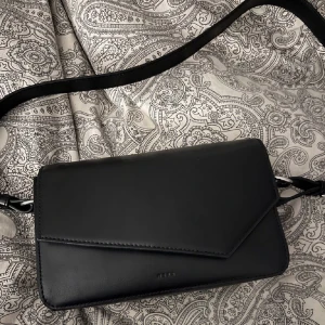 Svart märkes läderväska  - Snygg svart läderväska från åhlens i Märket Wera, köptes för 900 kr o är bara använd ca två gånger. Säljer pga inte min stil längre. Lägger upp igen.