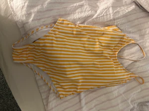 En gul baddräkt t salu - En randig vit gul baddräkt säljs för 35kr  