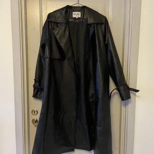 Skinn trenchcoat  - Säljer denna fina trenchcoat från NA-KD, storlek 36. Jättefint skick!