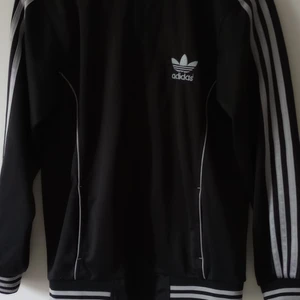 Adidas tröja med dragkedja  - Retro,finns ej att köpa längre. Svart med silver detaljer. Super fint skick. Storlek 36/38