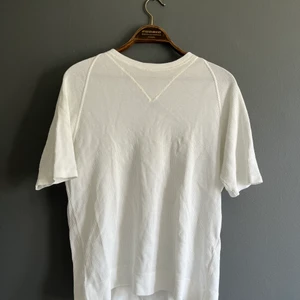 Vit vintage Prada t-shirt  - Vit t-shirt Prada. köpt vintage så kan inte garantera att den är äkta men tror det. Oavsett lite roligare än en vanlig vit t-shirt dock förstor för mig. 
