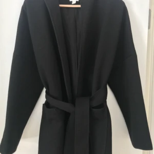 Svart kappa  - Kappa från hm i bra kvalitet. Köpt för 799 i storlek xs men passar även de som har s/m. Pga att kappan inte kom till användning säljer jag den och hoppas någon kan få användning av den. Jag har fler bilder på den så skriv privat om du vill ha dem. 