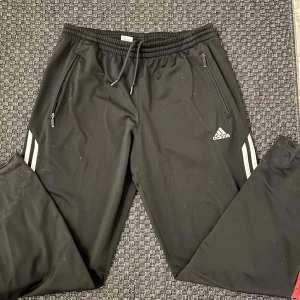 Adidas byxor - Lågmidjade blåa Adidas byxor med röda detaljer. Säljer då de är alldeles för långa på mig som är ca 160. Men de är såå snygga. 