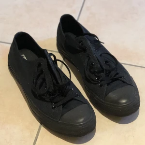 Låga svarta Converse  - Låga helsvarta Converse i storlek 42.  Nypris på Zalando är 750 kr men säljer dem nu för 200 kr. Knappt använda, 5 gånger kanske men säljs för att de inte kommer till användning Kan mötas upp men isf i Skanstull.