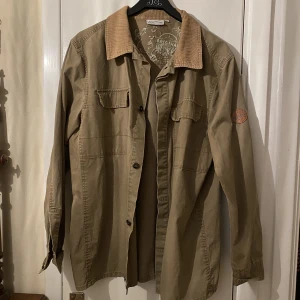 vårjacka - sjukt cool vintage brun/olivgrön vårjacka från disneyland resort i paris! köpt secondhand men aldrig använd så i bra skick!