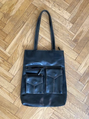 Handväska i läder - Fin handväska i läder, som har många fack och mkt utrymme.  Handtagen är lite slitna vid fästet. 
