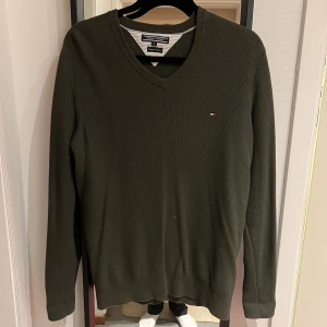 Stickad V-Neck tröja, Tommy Hilfiger - Mörkgrön/Oliv stickad V neck tröja från Tommy Hilfigher i användt skick