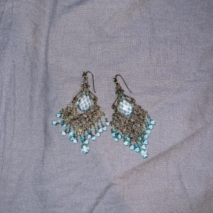 Blåa Örhängen - Vintage örhängen med stor blå diamant från plast och metal secondhand