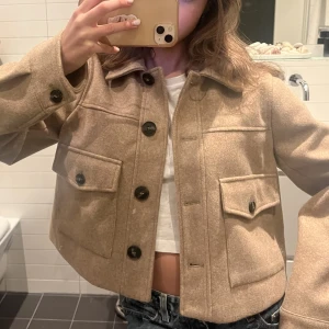 Zara kort kappa - Superfin kort kappa från zara! Ljusbrun/beige med bruna knappar. Nästan aldrig använt!💕💕 