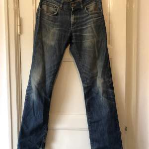 Ljus blåa jeans men låg midja ganska slitna men på ett snyggt sätt 